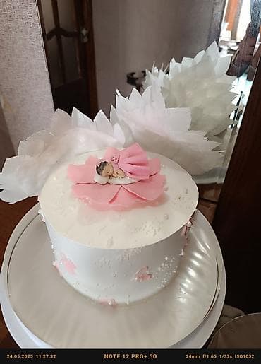 Ağ rəngli, yuvarlaq formalı tort. Üzərində çəhrayı rəngli güllər və