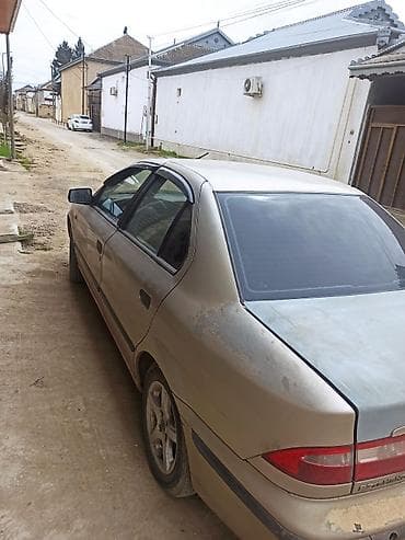 saipa 132 se: Açıq qəhvəyi rəngdə sedan tipli avtomobil. Avtomobilin ön hissəsində — 5