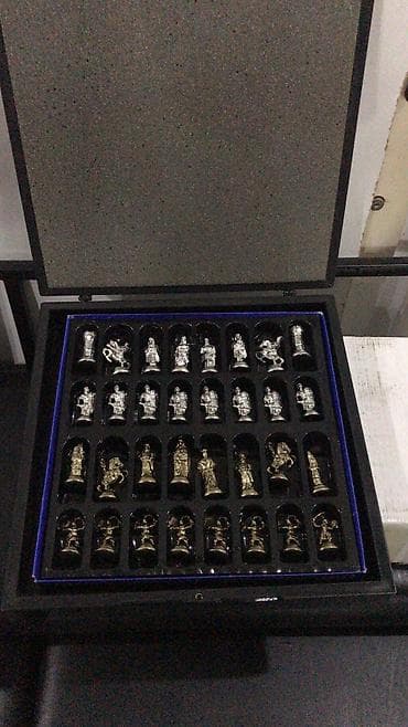 Şahmat dəsti, qızılı və gümüşü rəngli parçaları olan, qara rəngli