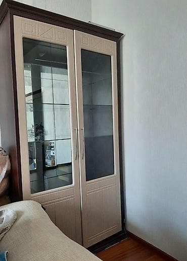 Qəhvəyi rəngli çərçivəyə malik, şüşə qapılı vitrin dolabı. İçərisində