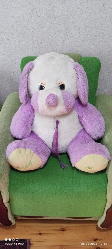 Ağ və bənövşəyi rənglərdə olan yumşaq oyuncaq it. Oyuncağın