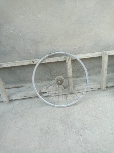 Gümüşü rəngli velosiped təkəri, dayanıqlı metal jantı və spikləri var
