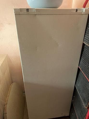 Ağ rəngli dik dondurucu (şaquli tip). Kompakt korpus, dar mətbəxlər və