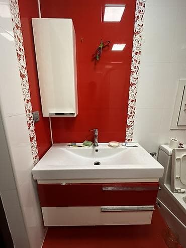 Qırmızı‑ağ rəng sxemində divara quraşdırılan hamam mebeli və əl‑üz