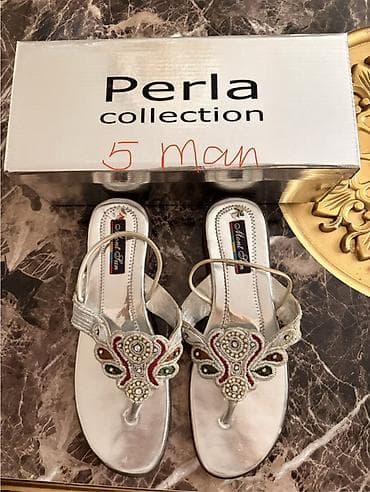 - Ağ rəngli deşikli rezin klon/kelek tipli şlaponlar. Üst hissədə — 2