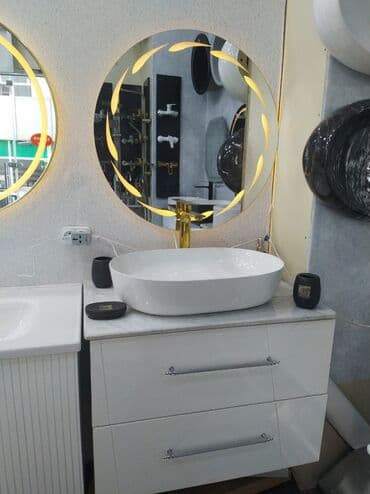 Ağ rəngli, oval formalı lavabo dəsti. Dəstə qızılı rəngli kran və LED