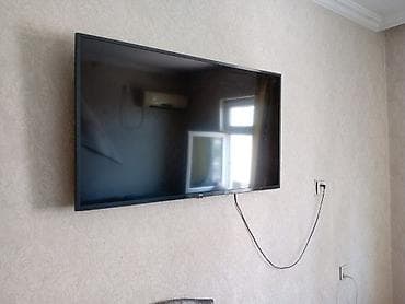televizor arxasi: LG LED televizor, təxmini 50–55 düym ekran ölçüsü (divara asılmış) — 2