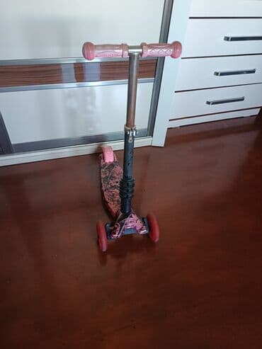 трюковой самокат: Çəhrayı rəngdə və qara naxışlı, üç təkərli uşaq skuteri. Skuterin — 1