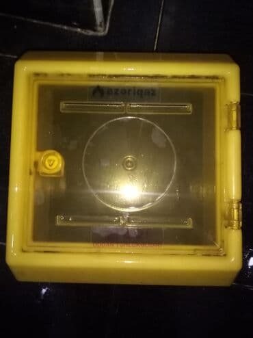 sayğac: Sarı rəngdə, şəffaf qapaqlı qaz sayğacı qutusu. Qutu qaz sayğacını — 2