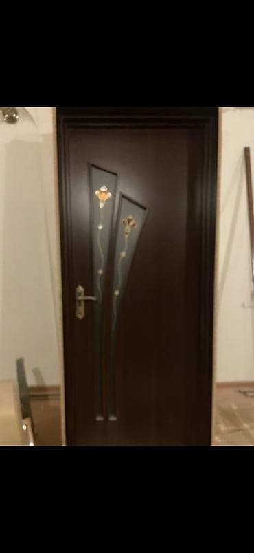 Daxili otaq qapısı – tünd qəhvəyi rəng, klassik dizayn. Üzərində şüşə