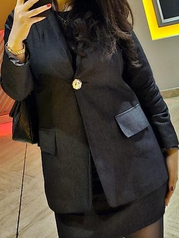 Qadınlar üçün klassik tünd rəngli dəst — pencək və qısa ətək. -