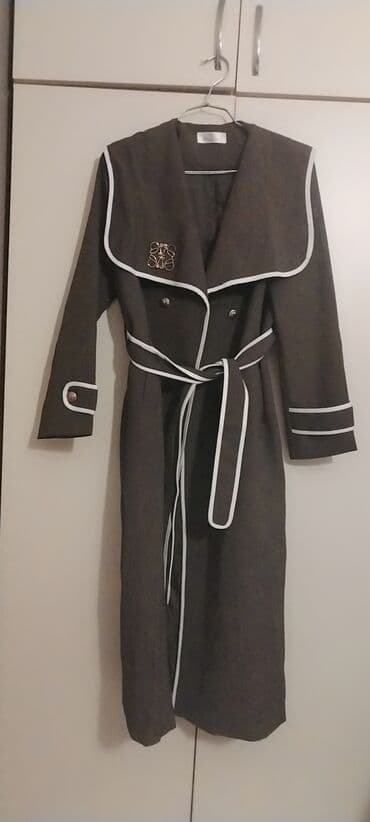 Qadın uzun trençkot bir dəfə geyinilib qalin materialdi boyuk bədəndi