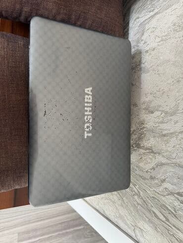 Toshiba markalı boz rəngli noutbuk. Cihazın üst qapağında Toshiba