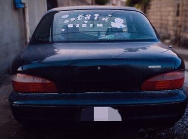 əllə çəkilmiş maşın şəkilləri: Kia Sephia sedan - Kuzov: 4 qapılı sedan, tünd yaşıl rəng - Ön hissə — 3