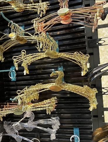 Asılqanlar: Dekorativ metal paltar asılqanları. Şəkildə qızılı, mis rəngli, qara — 1