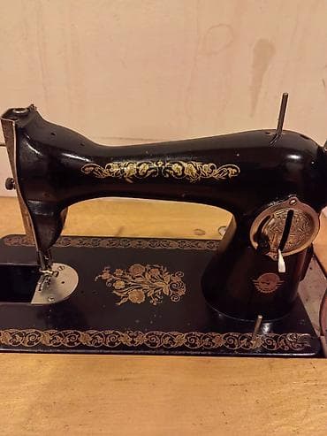 qedimi pullar: Klassik ayaq pedalı ilə işləyən tikiş maşını və taxta dolablı masa — 1