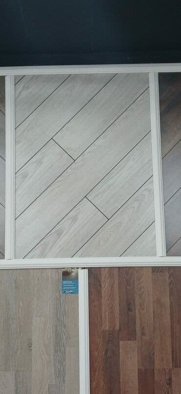 Ağac imitasiyalı, boz rəngli laminat döşəmə. Diagonal zolaqlar otağa