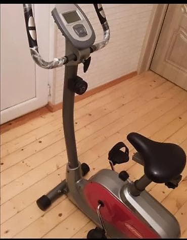 Qırmızı rəngli vurğuları olan boz rəngli stasionar velosiped. LCD