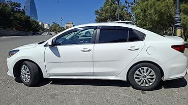 Kia: Kia Rio sedan – ağ rəng, Azərbaycan nömrə nişanı ilə. Şəhər və uzun — 7