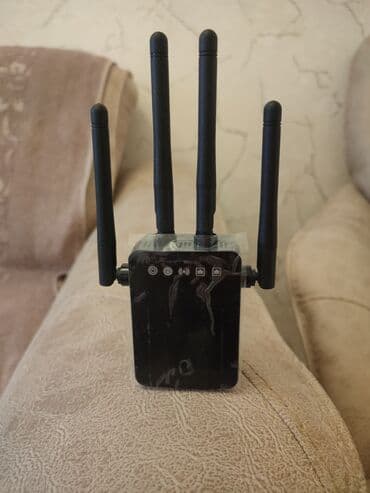 simsiz internet wifi: Qara rəngdə olan, dörd antenalı Wi-Fi gücləndiricisi. Evdə və ya — 1