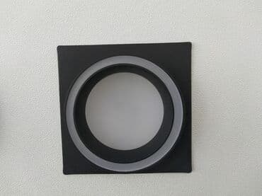 Qara kvadrat formalı divar lampası, mərkəzində dairəvi işıqlandırma