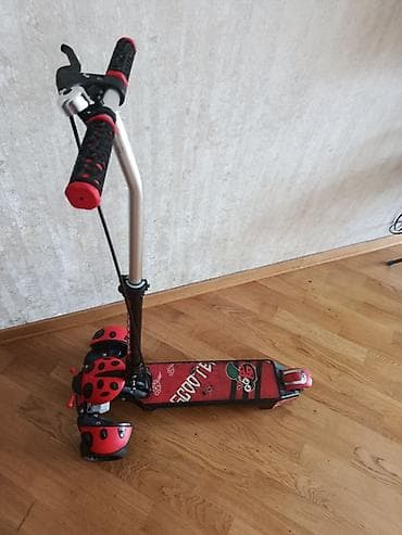 moped: Uşaq üçün üçtəkərli skuter. Qırmızı-qara rəngdədir və üzərində — 4