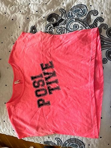 Neon çəhrayı rəngdə qolsuz qısa top (crop-top). Ön tərəfdə iri