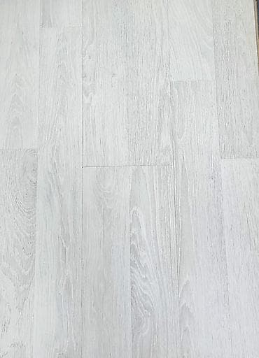 Ağac teksturasına malik açıq rəngli laminat döşəmə örtüyü. Müasir