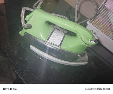 dərzi utusu: Klassik elektrik ütüsü – yaşıl korpuslu, metal altlıqla.derzi utusu — 2