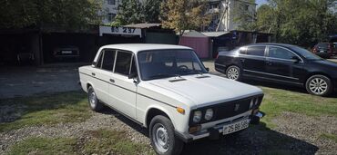 ваза напольная стеклянная высокая без узора: Ağ rəngli VAZ-2106 sedan avtomobili. Dörd qapılı bu avtomobil retro — 1