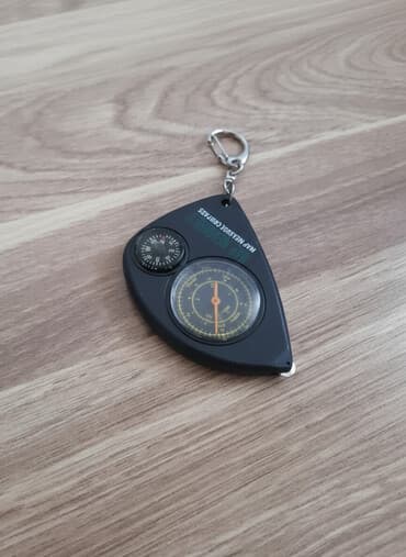 Qara rəngli, kiçik ölçülü, xəritə ölçmə kompas. Kompasın üzərində