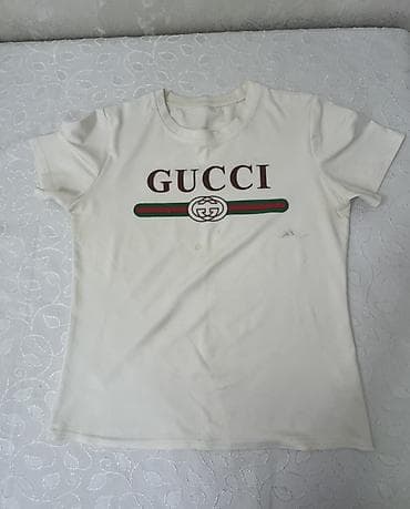 eros krem: Ağ rəngli qısaqol T‑shirt. Ön hissədə “GUCCI” yazısı və yaşıl‑qırmızı — 1