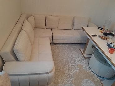 Künc divan dəsti – açıq krem rəngdə, yumşaq parça üzlü. L‑şəkilli