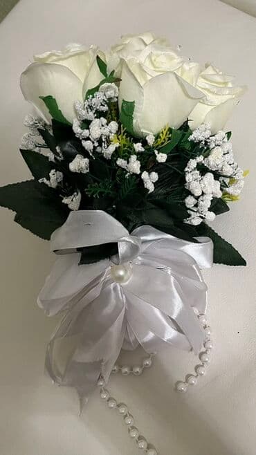 Ağ güllərdən və ağ rəngli kiçik çiçəklərdən ibarət zərif buket. Buket