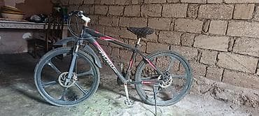 Dağ velosipedi qara rəngdədir və qırmızı detallarla bəzədilib