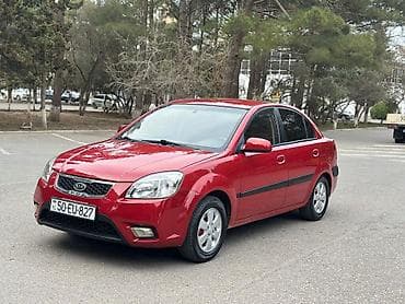Kia Rio sedan – qırmızı rəng, 4 qapı, kompakt şəhər avtomobili. -