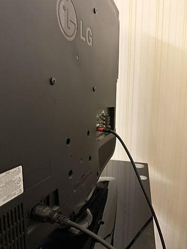 ailə tv: LG LCD/LED televizor, təxminən 37–42” diaqonal ekran. Qara korpus — 4