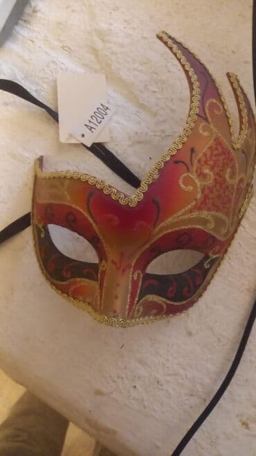 xoncaların satışı: Qırmızı, narıncı və qızılı rənglərdə olan Venesiya maskası. Maskada — 1