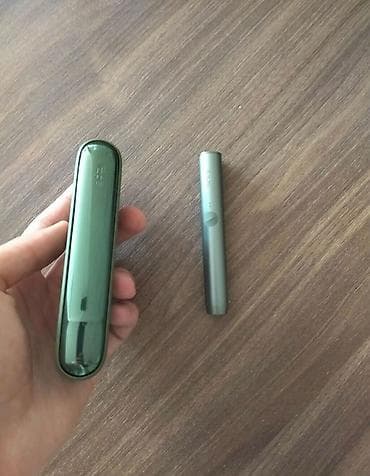 IQOS siqaret qızdırma cihazı – yaşıl rəngli şarj qutusu və gümüşü