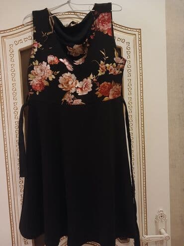 Qadın paltarı – qara rəngdə, A-kəsim ətəkli. Üst hissə çiçək motivli