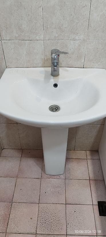 sud separatoru: Ağ keramika ayaqüstü hamam lavabosu və qarışdırıcı kran dəsti. - — 1