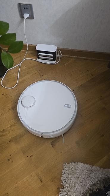 Ağıllı robot tozsoran – ağ rəngdə, dairəvi korpuslu, dok-stansiya