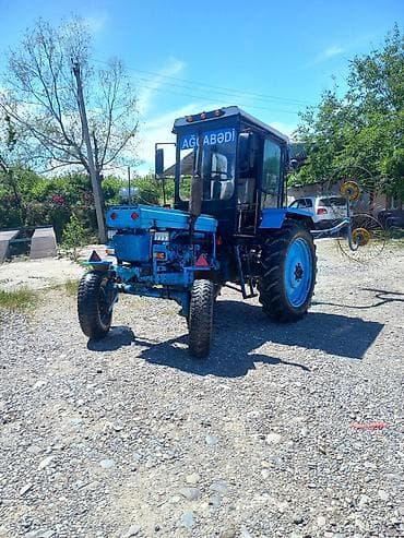 Mavi rəngli kabinəli kənd təsərrüfatı traktoru və arxadan qoşulan ot lalafo.az -da Mavi rəngli kabinəli kənd təsərrüfatı traktoru və arxadan qoşulan ot