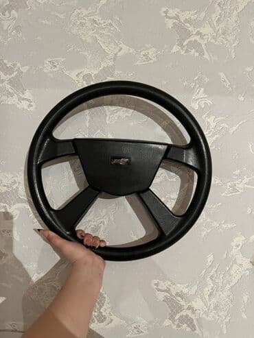 niva rolu: Avtomobil sükanı, qara rəngdə və dörd qolu var, mərkəzində "Chevrolet" — 1