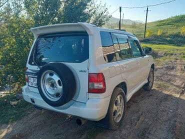 турбо аз трактор: Ağ rəngli, 4 qapılı Mitsubishi Pajero SUV. Avtomobilin arxa hissəsində — 3