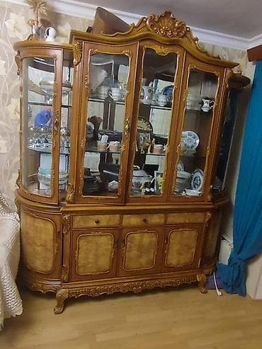 Nəfis oyma detalları və şüşə qapıları olan taxta vitrin şkafı. Bu