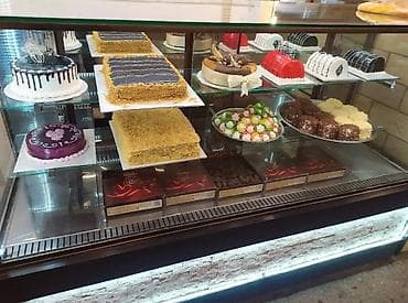 Şirniyyat vitrinində müxtəlif tort və desertlər - Kremli və şokoladlı