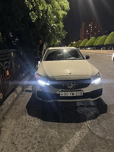 Ağ rəngli Mercedes-Benz C-Class sedan. Avtomobilin ön hissəsində iri