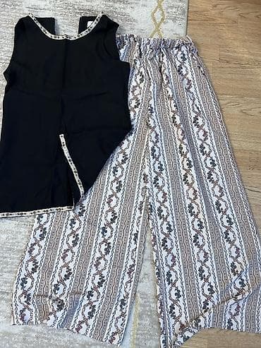 İkihissəli qadın geyim dəsti - Üst: Qolsuz, qara rəngli bluz. Yaxa və