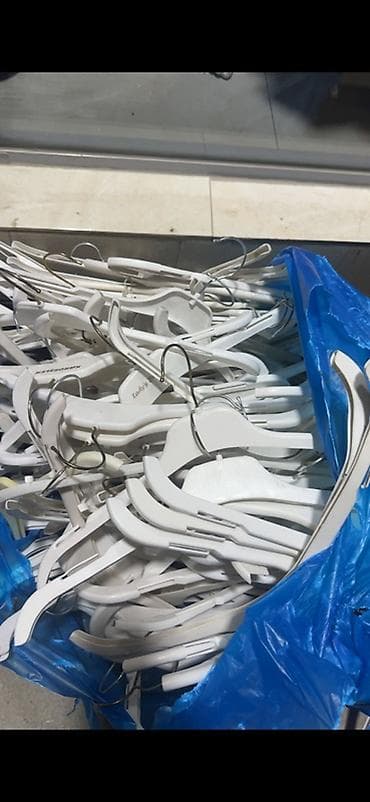 Ağ rəngli plastik geyim asılqanları toplusu. Bu asılqanlar möhkəm